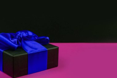 Siber Pazartesi Satışı. Kırmızı fiyonklu siyah hediye kutusu, renkli bir arka plan. İndirim, online alışveriş kavramı