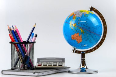 Küre, defter yığını ve kalemler. Okul çocukları ve öğrenciler için aksesuarlar. Okul konseptine geri dönelim..