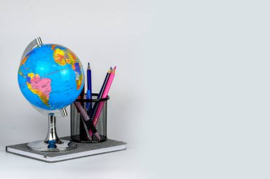 Küre, defter yığını ve kalemler. Okul çocukları ve öğrenciler için aksesuarlar. Okul konseptine geri dönelim..