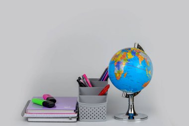 Küre, defter yığını ve kalemler. Okul çocukları ve öğrenciler için aksesuarlar. Okul konseptine geri dönelim..