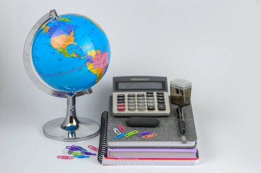 Küre, defter yığını ve kalemler. Okul çocukları ve öğrenciler için aksesuarlar. Okul konseptine geri dönelim..