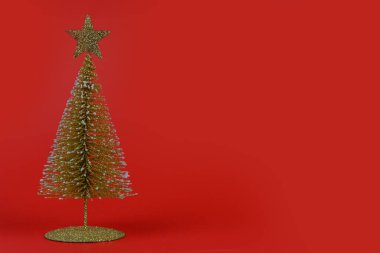 Noel kompozisyonu. Kırmızı arka planda küçük bir Noel ağacı. Yeni yıl konsepti.