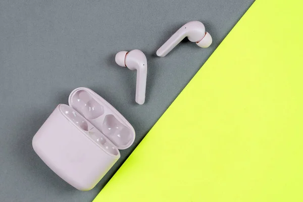 stock image Flat lay storage concept: headphones and smartphone on pastel color background. wireless headphones on a pink gray background, top view, copy space.