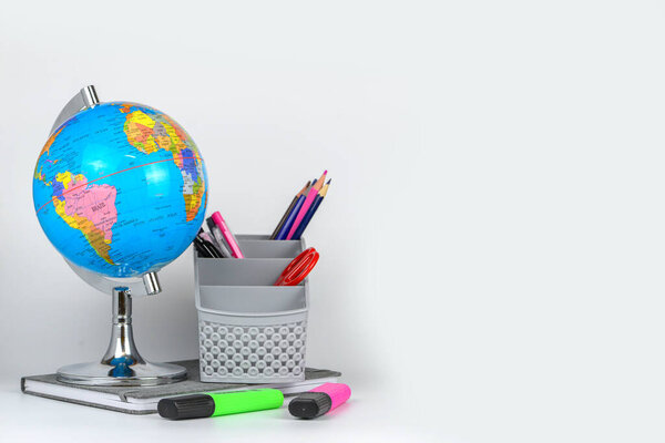Globe, notebook stack and pencils. Accessories for schoolchildren and students. Back to the school concept.