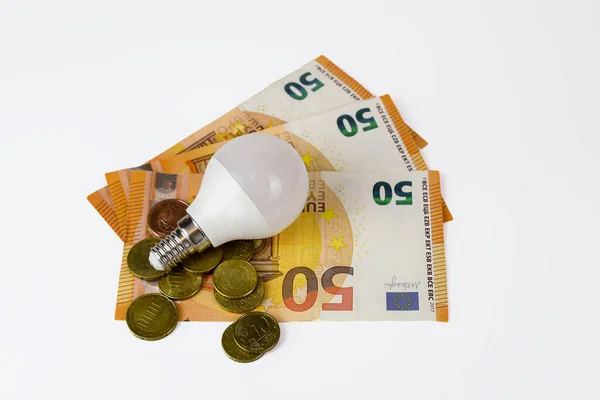Energy saving light bulb and euro banknotes. Energy saving and savings concept