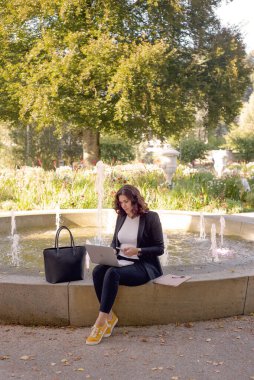 İş kadını takım elbiseli, bilgisayarı park halinde. Yüksek kalite fotoğraf