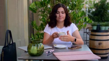 Kahve ya da kapuçino içen genç bir kadın. Yüksek kaliteli FullHD görüntüler