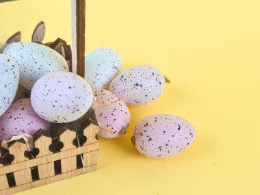 Quail eggs in a basket on a yellow background. High quality photo clipart