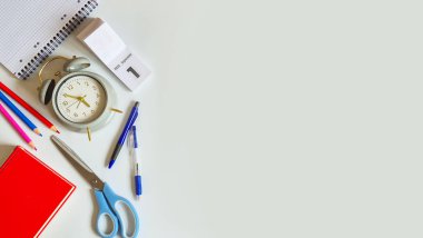 Alarmlı saat, okula geri dönen bir defter ve ağlı arka planda farklı kağıtlar. Yüksek kalite fotoğraf