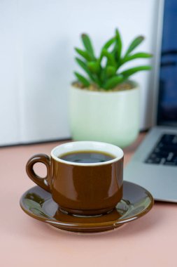 Bilgisayarlı, kitaplı, serbest çalışan, iş ve eğitim konsepti olan bir fincan kahve. Yüksek kalite fotoğraf