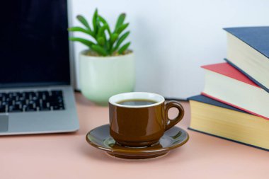 Bilgisayarlı, kitaplı, serbest çalışan, iş ve eğitim konsepti olan bir fincan kahve. Yüksek kalite fotoğraf