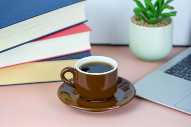 Bilgisayarlı, kitaplı, serbest çalışan, iş ve eğitim konsepti olan bir fincan kahve. Yüksek kalite fotoğraf