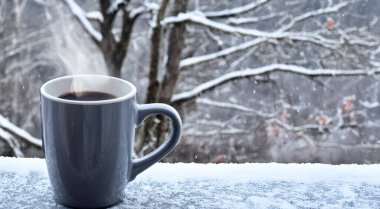 Kış karlı arka planda bir fincan sıcak kahve. Yüksek kalite fotoğraf