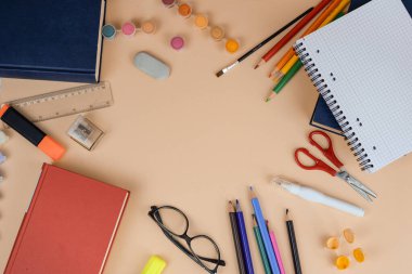 Bir masa çeşitli okul malzemeleriyle süslenir, öğrenme ve yaratıcılığa hazır düzenli ama renkli bir çalışma alanı oluşturulur.