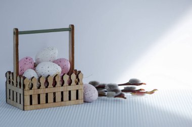 Beyaz arka planda söğüt ağacı olan ahşap bir sepette paskalya yumurtaları. Yüksek kalite fotoğraf