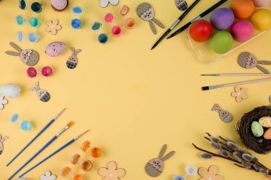 Fırça ve Boyanmış Renkli Paskalya Yumurtaları Metin İçin Yer Olan Sarı Arkaplanda. 