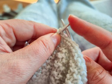 Yatıştırıcı renklerde ustalıkla örgü ören, örmenin güzel sanatını vurgulayan yakın plan bir fotoğraf.