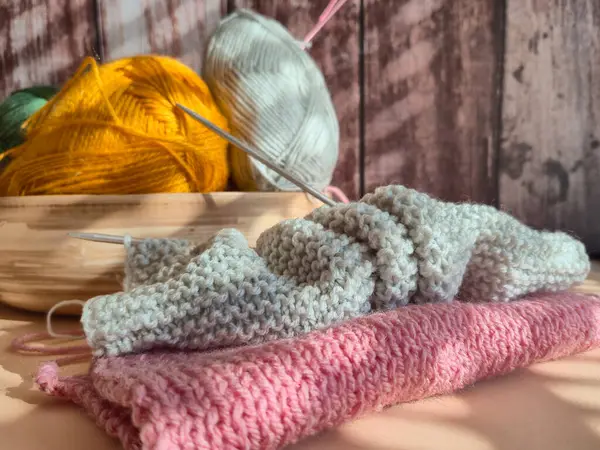 Pastel iplikler ve sıcak aydınlatma ile huzurlu bir örgü sahnesi, sanat severler için mükemmel bir atmosfer yaratıyor.