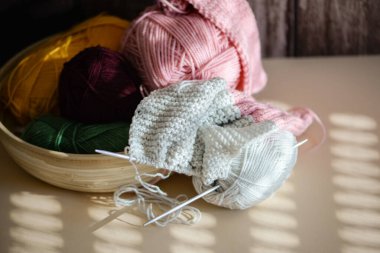 Rengarenk iplikler ve iğnelerle süslenmiş güzel bir örgü sahnesi, sanatsal fikirlerinize ilham veriyor.