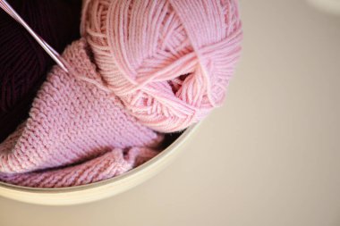 Yumuşak pembe iplik ve karmaşık bir şekilde örülmüş kumaş sergisi, el yapımı ve DIY projeleri için mükemmel.