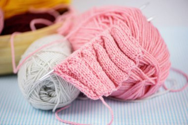 Pembe ve gri tonlarında, örgü iğneli, yaratıcı el işi projeleri için mükemmel bir iplik.
