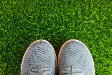 Gri Spor Koşu Ayakkabıları ve yeşil çimlerde bir şişe su. Spor ve rahatlama konsepti. Yüksek kalite fotoğraf