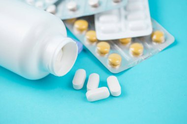 Mavi bir arkaplanda çeşitli ilaç ve haplar var. Mesaj için de yer var. Yüksek kalite fotoğraf