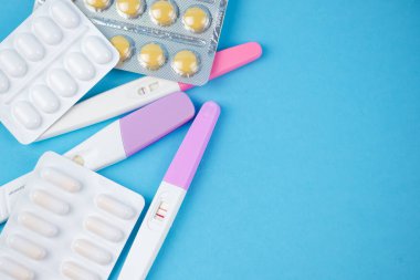 Mavi arka planda pozitif hamilelik testi, aile planlaması. Tüp bebek teması, kısırlık tedavisi. Yüksek kalite fotoğraf