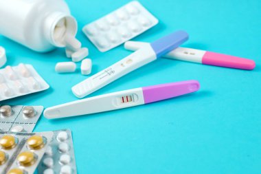 Pozitif hamilelik testi ve mavi arka planda bir sürü ilaç, aile planlaması. Doğum kontrol hapları. Yüksek kalite fotoğraf