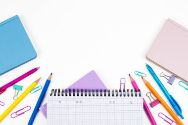 Renkli bir kırtasiye malzemesi ve temiz beyaz arkaplan üzerine dizilmiş güzel dizayn edilmiş not defterleri.