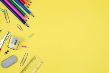 Yaratıcılığa ilham vermek ve üretkenliği artırmak için sarı arka planda güzel düzenlenmiş canlı kırtasiye ürünleri