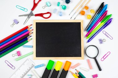 Boş bir karatahtanın etrafında renkli bir okul malzemesi yatıyordu. Eğitim teması ve fikirleri için mükemmeldi.