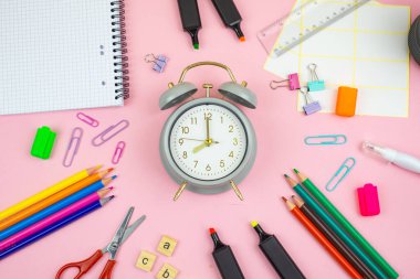 Kırtasiye aletleri ve klasik bir çalar saat de dahil olmak üzere temel çalışma malzemelerinin düzenli bir gösterimi