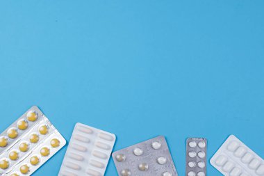 Mavi bir arkaplanda çeşitli ilaç ve haplar var. Mesaj için de yer var. Yüksek kalite fotoğraf