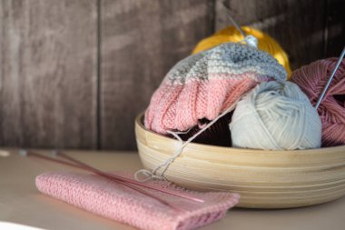 Renkli ipliklerden, örgü iğnelerinden ve ahşap bir kasede çeşitli zanaatlardan oluşan samimi ve davetkar bir düzen.