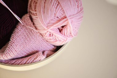 Yumuşak pembe iplik ve karmaşık bir şekilde örülmüş kumaş sergisi, el yapımı ve DIY projeleri için mükemmel.