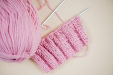 Canlı pembe örülmüş kumaş sergileniyor. İğne ve iplik sergileniyor. Çeşitli el işi projeleri için mükemmel.
