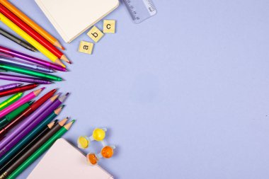 Renkli kalemler, defterler ve daha birçok şey gibi canlı ve renkli bir okul malzemesi koleksiyonu.