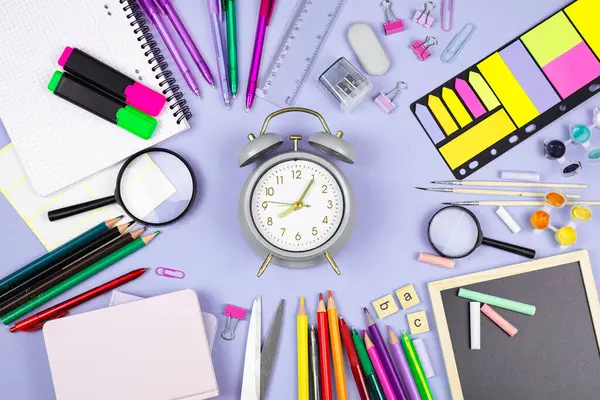 Çalışma oturumlarında üretkenliği artırmak için renkli kırtasiye, saat ve araçlara sahip organize bir masa