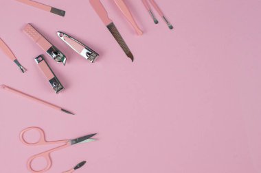 Yumuşak pembe bir yüzey üzerinde moda pembe tımar araçları koleksiyonu, güzellik ve kişisel bakım için ideal..