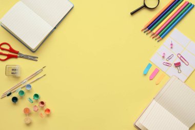 Yaratıcılığı ve sanatsal ifadeyi geliştirmek için not defterleri, renkli kalemler ve el işi araçları olan canlı bir çalışma alanı