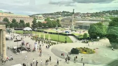 Almanya Stuttgart 16.07.2025 Değişik kalabalıklar, yeşillik ve ilgi çekici mimari ile hareketli bir şehir meydanı, canlı bir şehir manzarası oluşturur.