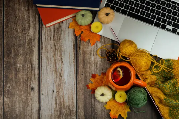 Sıcak bir sonbahar temalı çalışma alanı, dizüstü bilgisayarı, rahat çay kupası ve keyif veren mevsimlik dekorasyonlar.