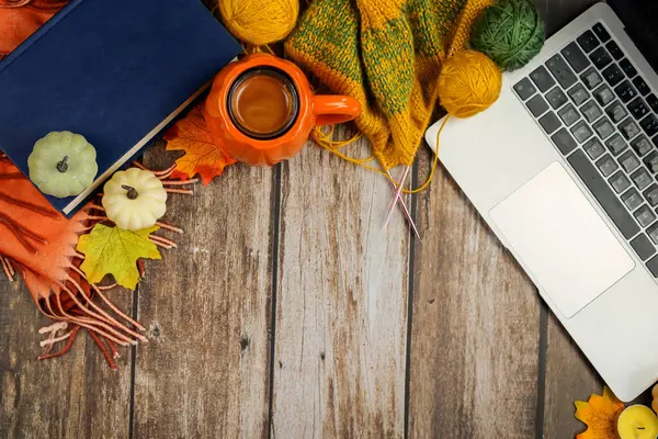 Dizüstü bilgisayar, kahve ve üretkenliği arttıran mevsimlik dekorlarla dolu samimi bir sonbahar çalışma alanı hayal edin.