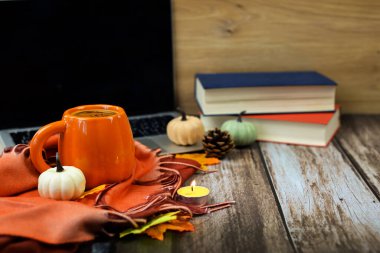 Hoş ve ılık bir sonbahar kurgusu güzel bir kupa, istiflenmiş kitaplar, yumuşak mumlar ve büyüleyici mevsimlik dekorlar sergiliyor.