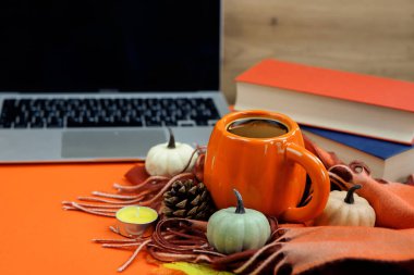 Sonbahar dekorlu sıcak bir fincan kahve, kitaplar ve dizüstü bilgisayar, şükran günü. Yüksek kalite fotoğraf