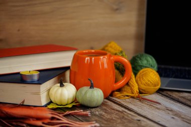 Sıcak ve cezbedici bir sonbahar Vignette sergi kitapları, rahat bir kupa, mini balkabakları, ve canlı renkli iplik