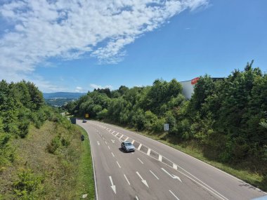 Parlak mavi gökyüzünün altında canlı yemyeşil bir otobanın güzel ve pitoresk manzarası.
