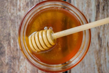 Kavanozdaki altın balın büyüleyici bir görüntüsü. Mutfak kullanımları ve sağlık hizmetleri için mükemmel.