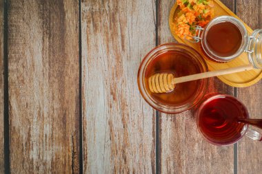 Sıcak bir organik bal, bitkisel çay ve kırsal bir masada ustalıkla hazırlanmış taze malzemeler.